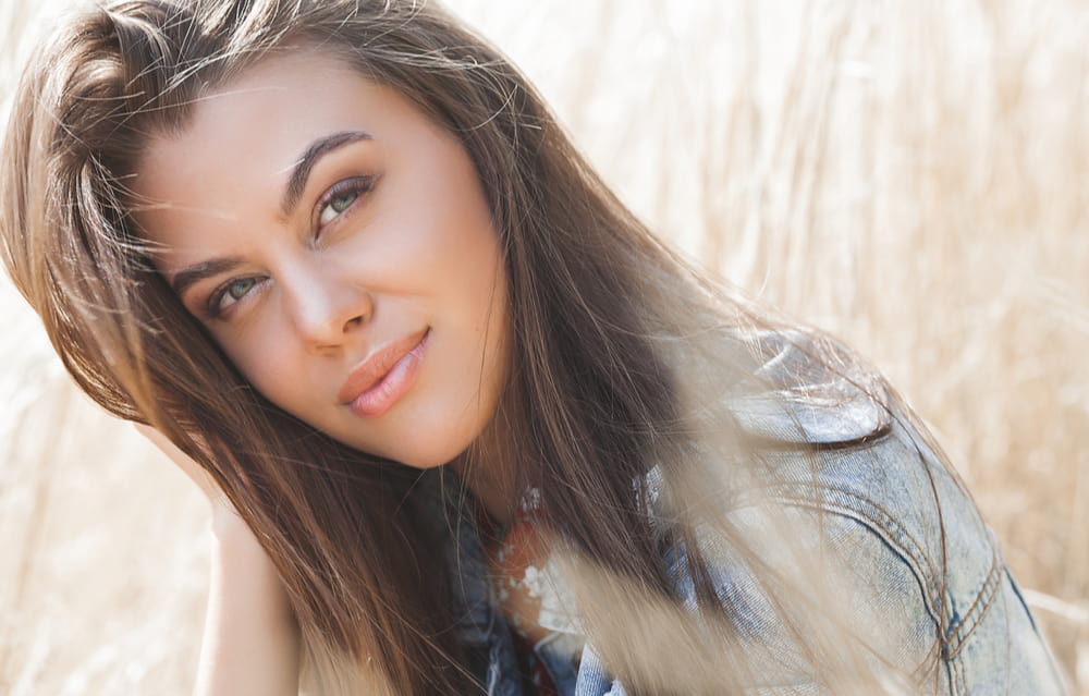 Pretty woman smiling at the camera outdoors in a field