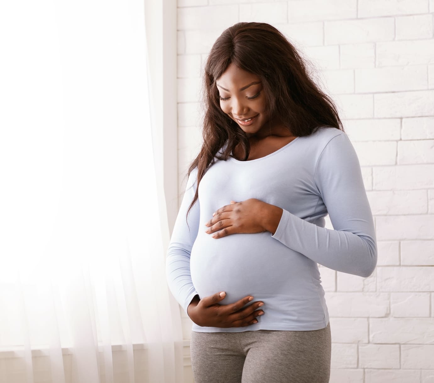 Young black pregnant woman admiring her belly