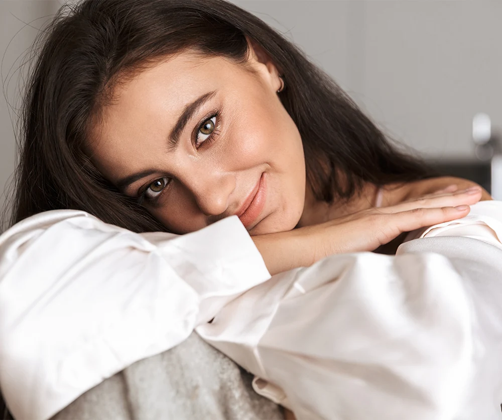 confident 30's woman with soft, glowing skin looking into camera